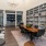 a room with a table chairs and a shelf with books on it